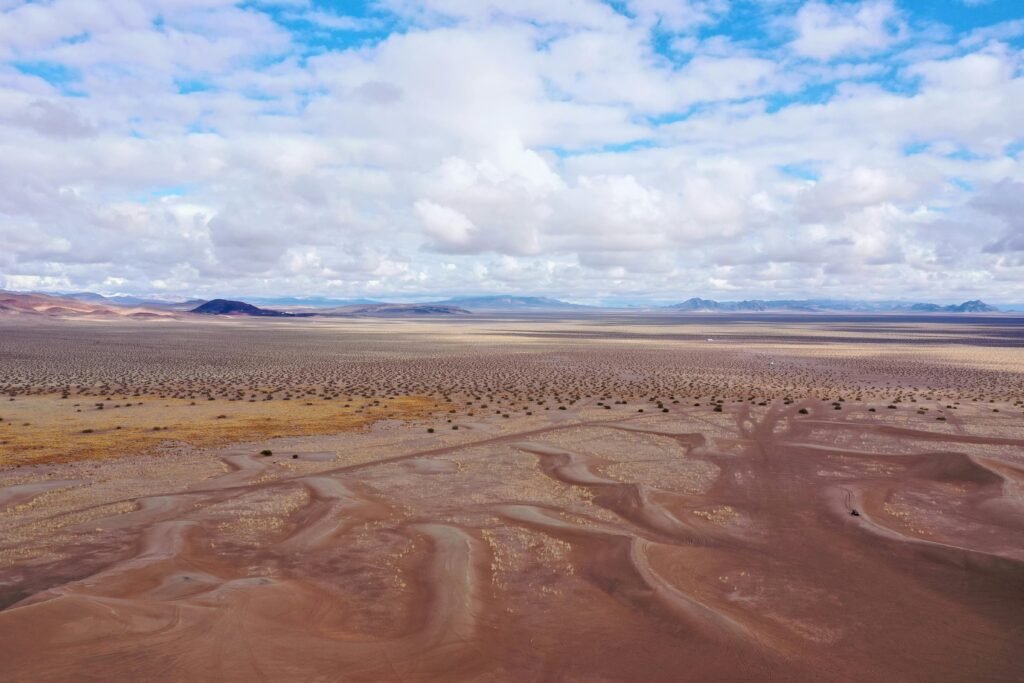 Aerial view of a vast, arid desert landscape in Beatty, Nevada under a bright sky.